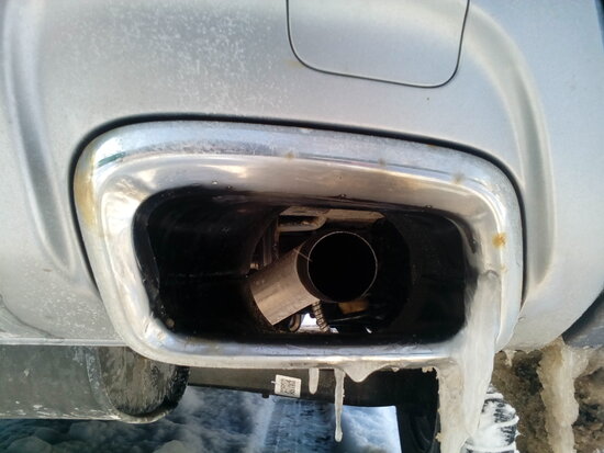 Ржавчина на декоративной рамке выхлопной трубы Джили Атлас (справа)